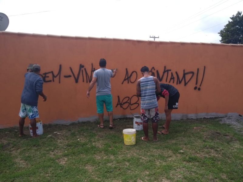 Apenados limpando pichações