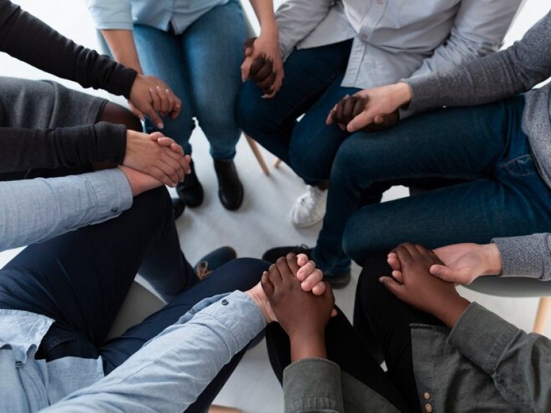 vista-superior-pacientes-em-pe-em-circulo-e-de-maos-dadas_23-2148398454